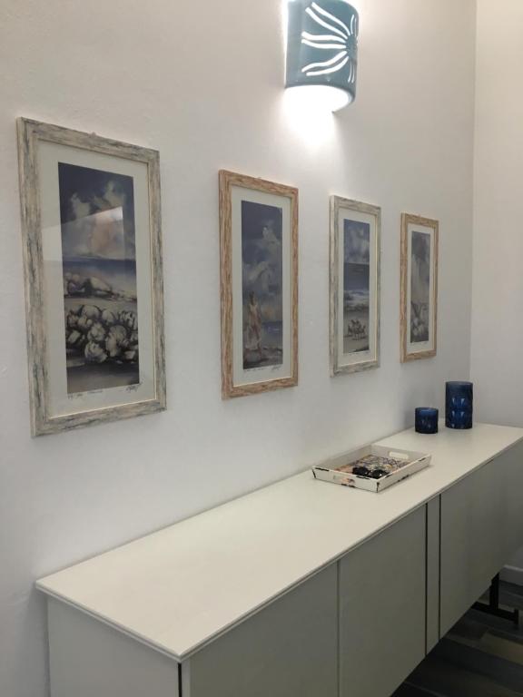 卡拉古诺内Maison Turquoise的墙上有4张照片的白色柜台