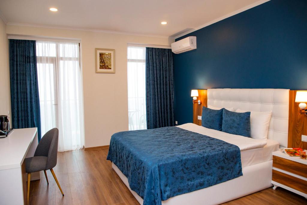 巴统Aqua Batumi Hotel & Apartments的酒店客房,设有床铺和蓝色的墙壁