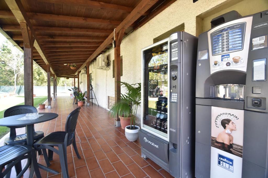 格罗塞托港伊莎贝拉别墅酒店的户外庭院配有饮料冷却器和桌子