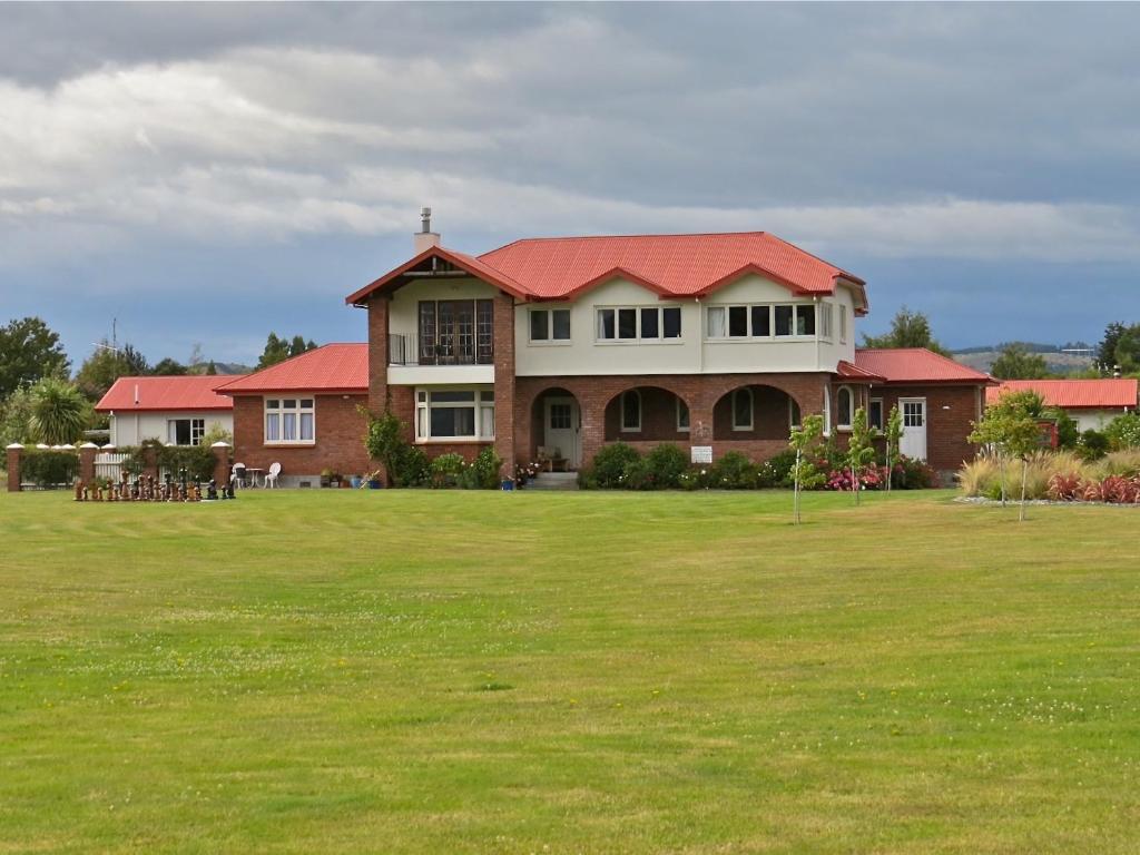 蒂阿瑙蒂安瑙旅舍的绿色田野上带红色屋顶的大房子