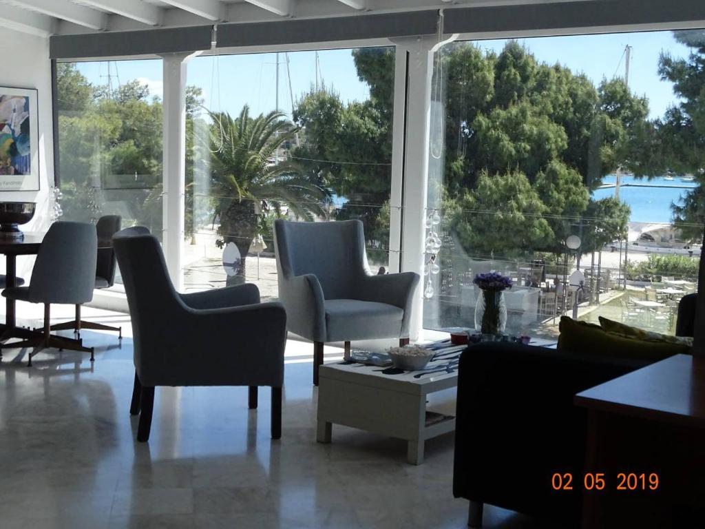 波多河丽Luxury Loft in Porto Heli !!!的客厅配有椅子和大窗户