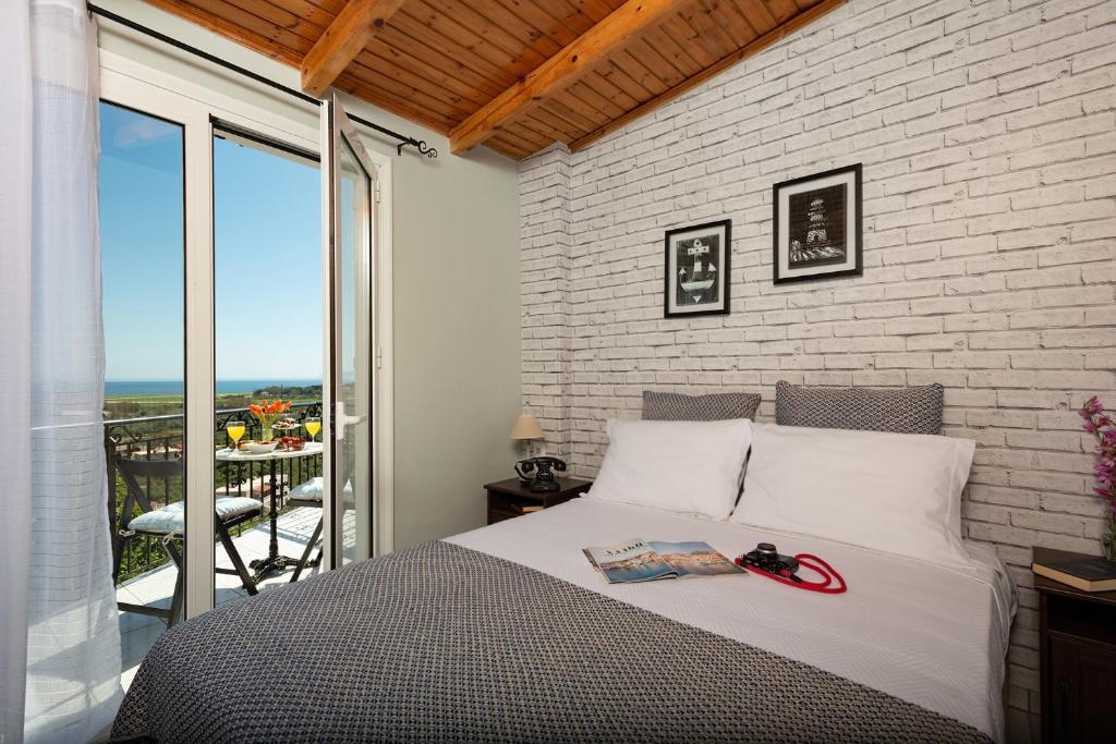 塔伦蒂斯Stefanos House的一间卧室设有一张床和砖墙