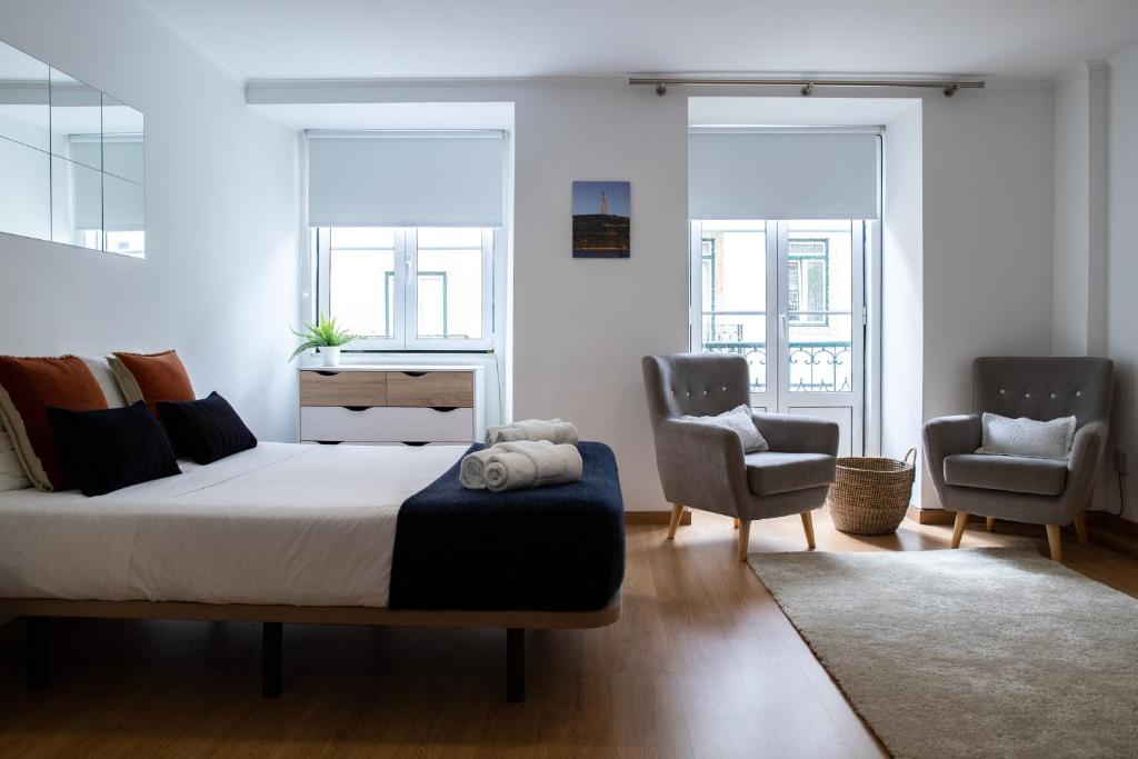 里斯本Belém - Fully equiped Studio的一间卧室配有一张大床和两把椅子