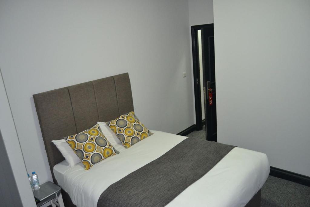伦敦伦敦曼诺豪斯酒店的一间卧室配有带枕头的床