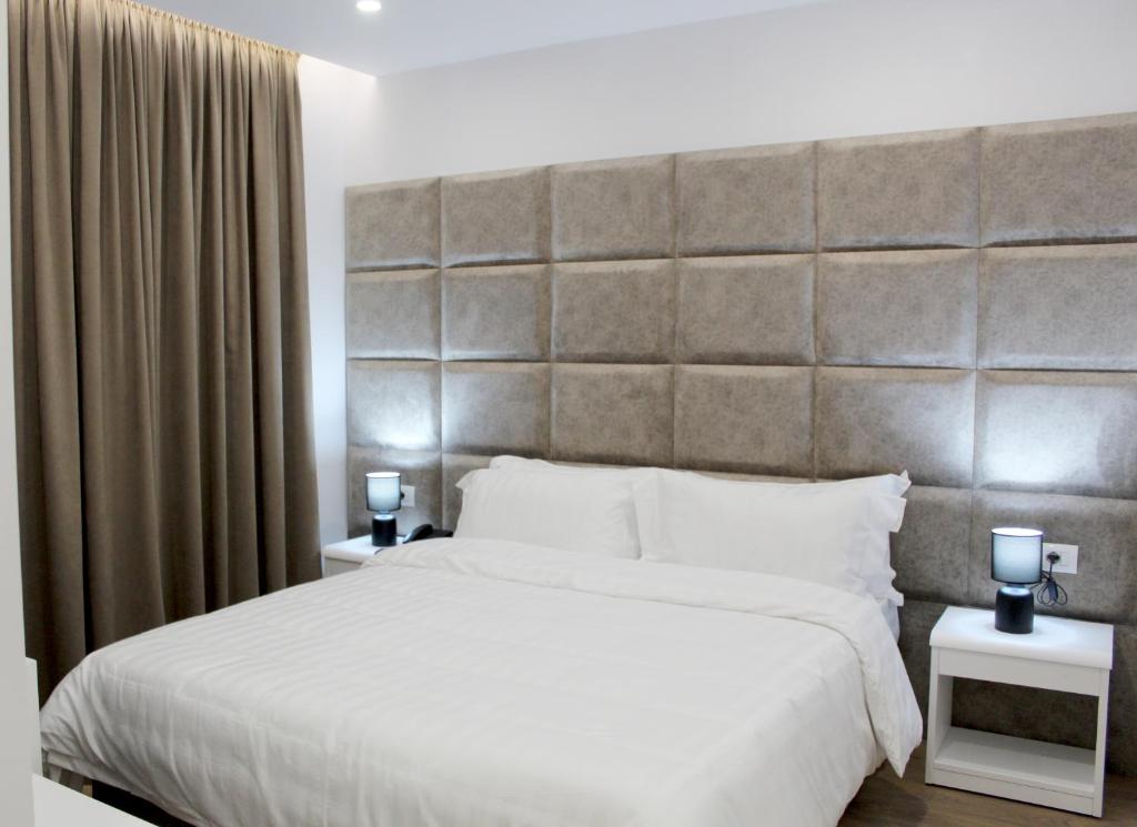 地拉那Ramel Hotel的一间卧室配有一张大床和大床头板