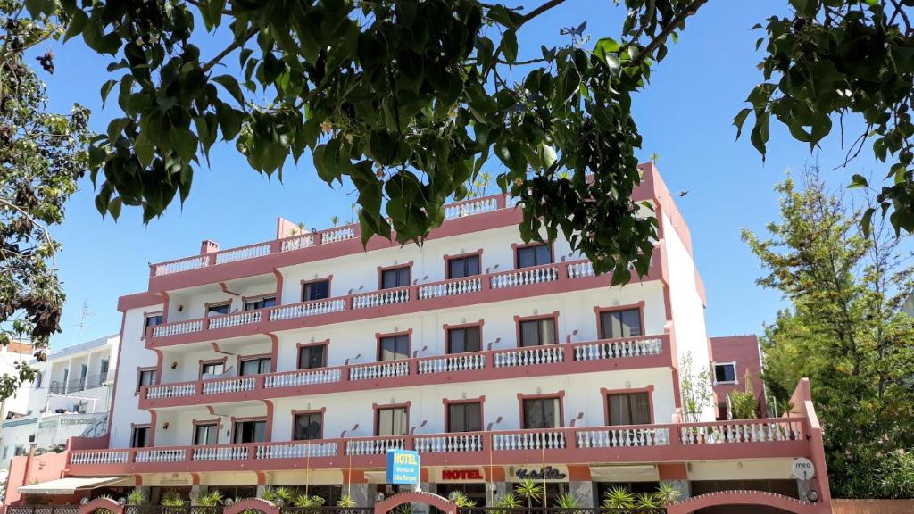 拉戈斯Boutique Hotel Marina S. Roque的一座大型白色建筑,设有红色阳台