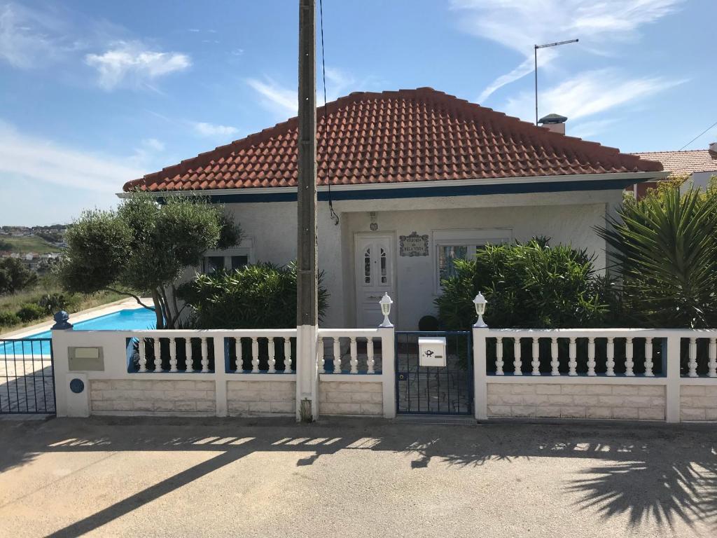 卡帕里卡海岸Vivenda da bela vista的白色的房子,设有围栏和游泳池