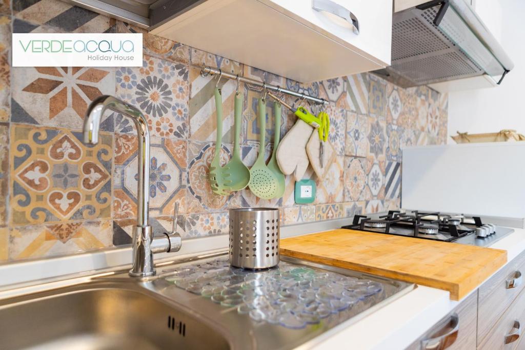 马里内拉Verdeacqua Holiday House的厨房配有水槽和炉灶 顶部烤箱