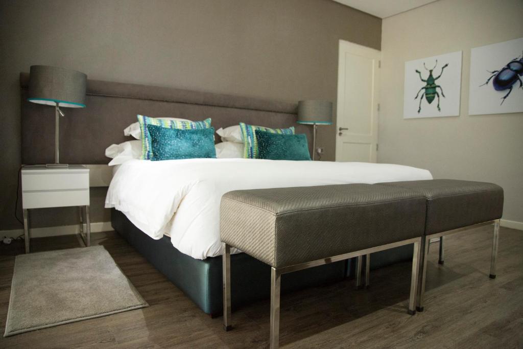 卢萨卡Le Elementos Boutique Hotel的一间卧室配有一张带蓝色枕头的大床