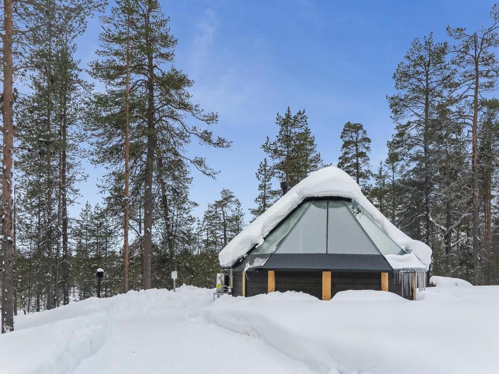 KakslauttanenHoliday Home Arctic light hut by Interhome的一座被雪覆盖的建筑,有树为背景