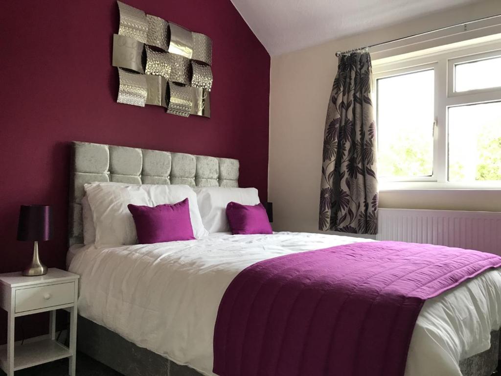 切姆The Avenues的紫色卧室配有一张带紫色枕头的大床