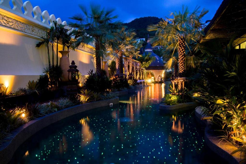 卡塔海滩萨瓦斯德乡村酒店的棕榈树和灯的别墅内的游泳池