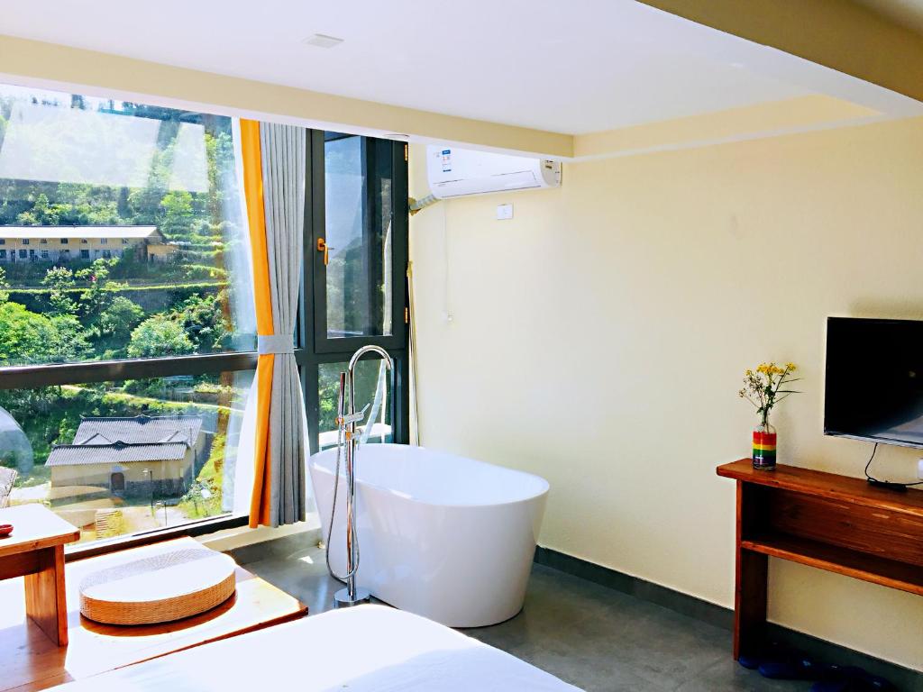 Yunhe云和梯田凤隐民宿客栈的带浴缸的浴室和大窗户