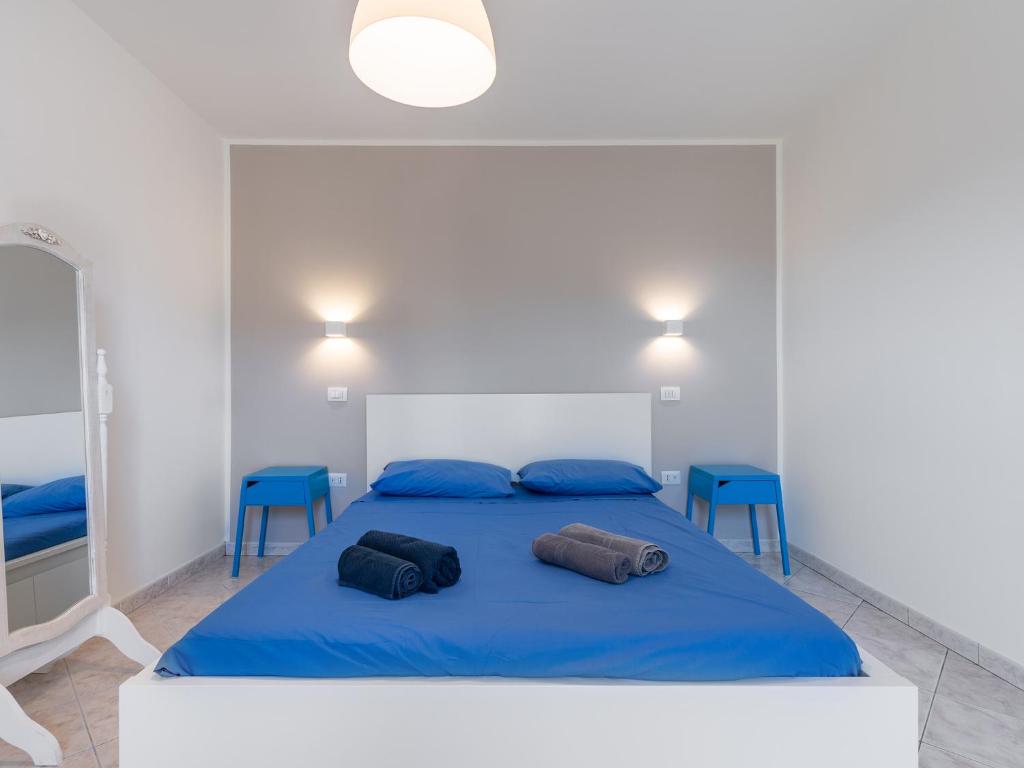 夸尔图-圣埃莱娜Spritz Bed & Breakfast的一间卧室配有蓝色的床和蓝色的椅子