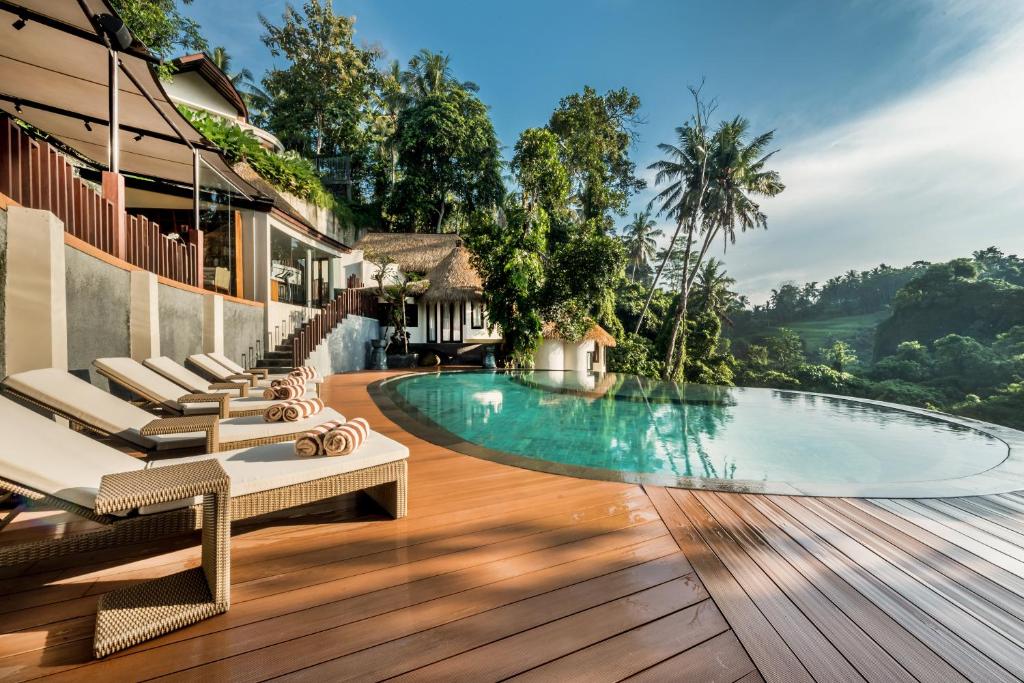 乌布Tanadewa Resort Ubud Bali by Cross Collection的一个带游泳池和躺椅的度假胜地