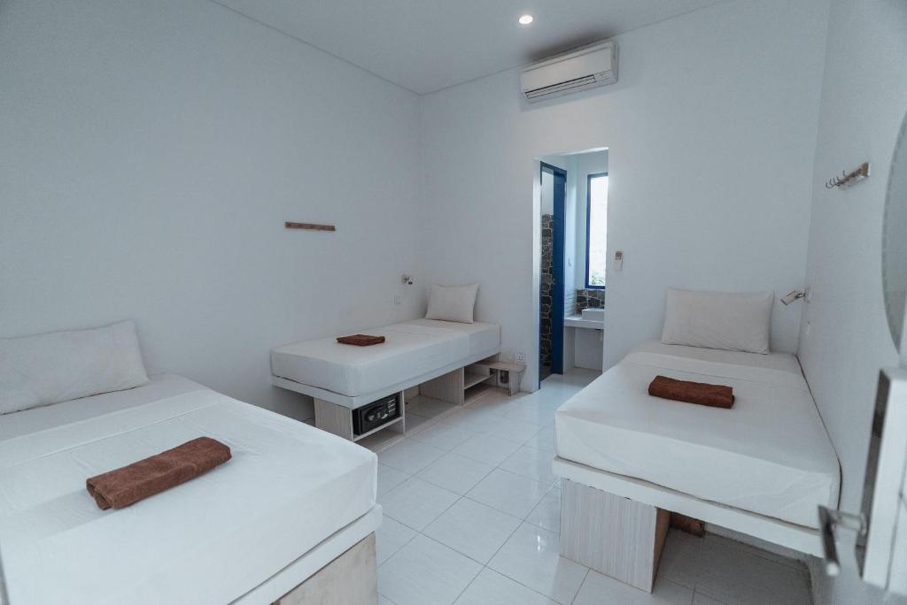 吉利特拉旺安Atlas Gili的白色的客房设有两张床和盥洗盆