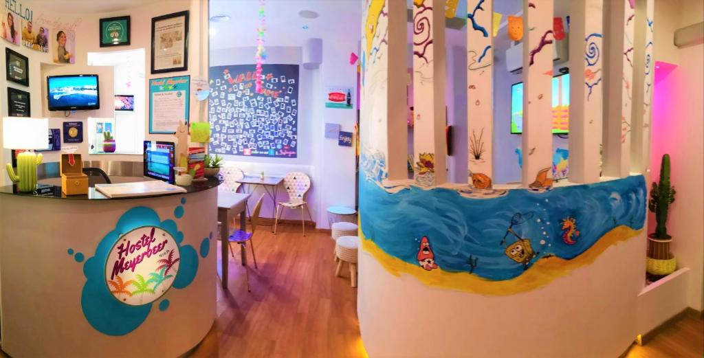 尼斯梅耶皮尔沙滩酒店的一间设有书桌的房间和一间带冲浪板的房间
