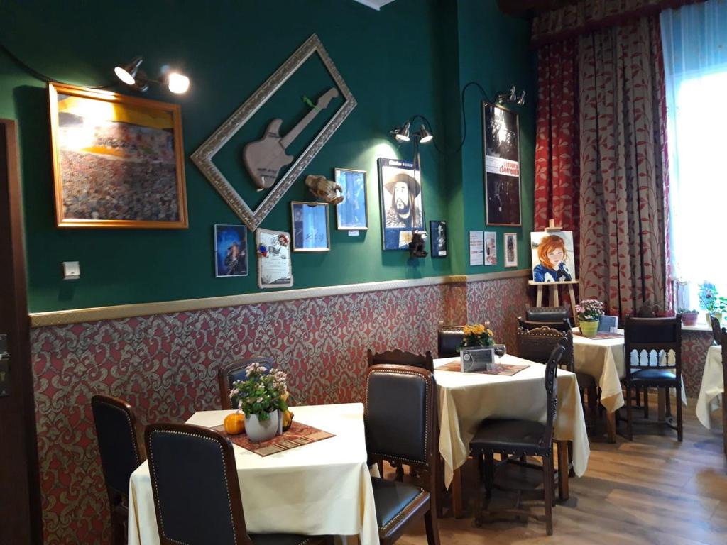 什切青Willa Sorrento的用餐室设有桌椅和绿色的墙壁