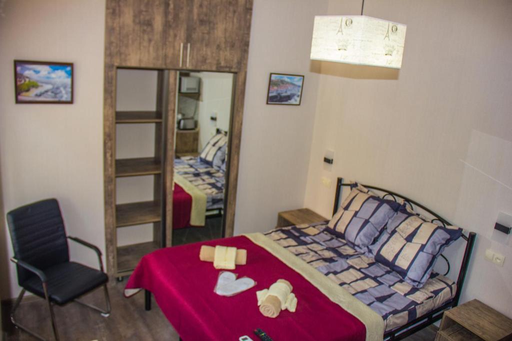 第比利斯Old Tbilisi apartments的一间卧室配有一张床、一把椅子和镜子
