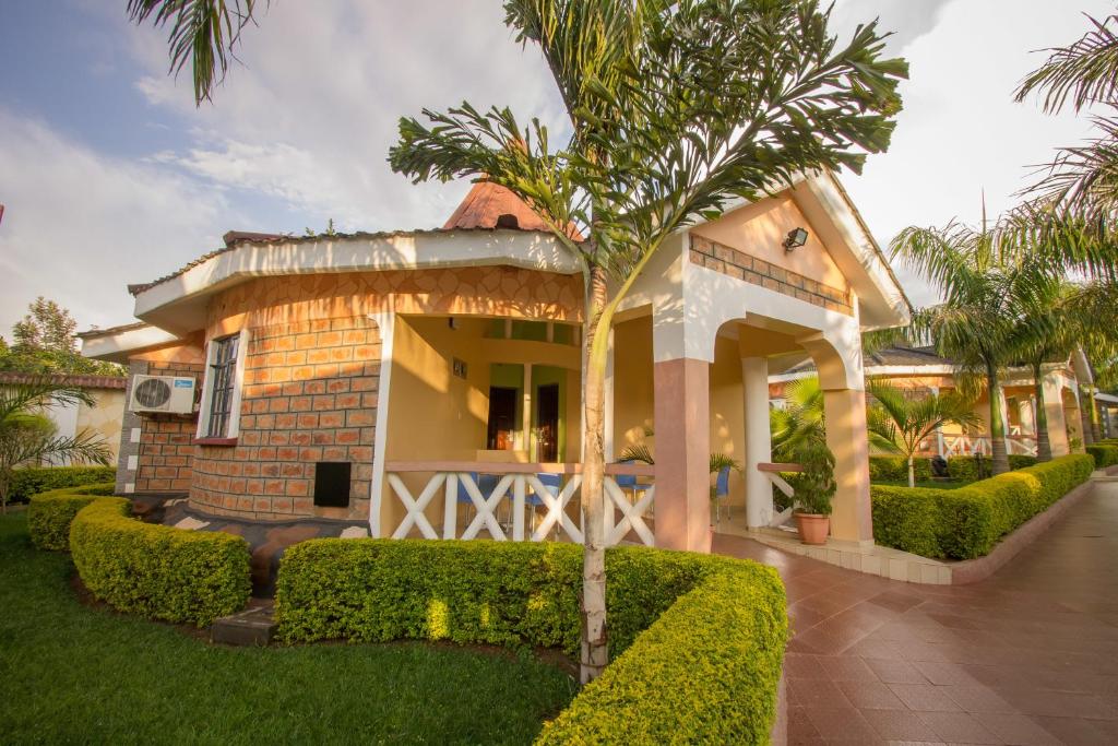 KisiiHotel Nyakoe Kisii的前面有棕榈树的房子