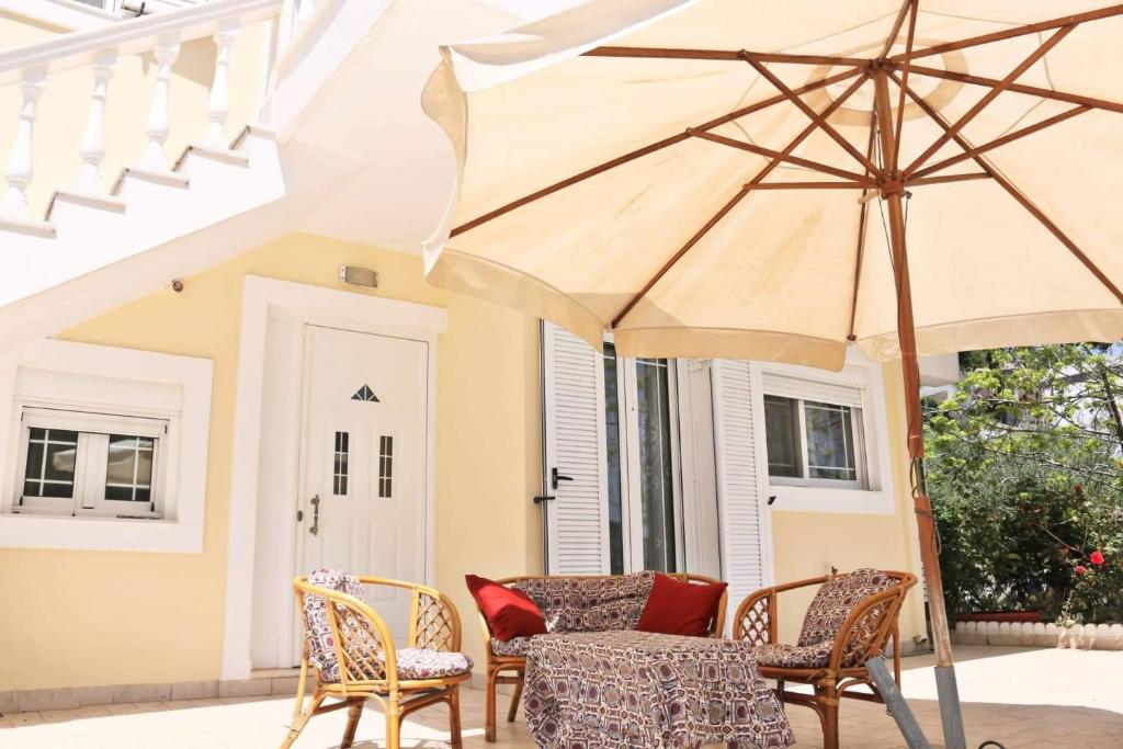 VoládhaEntire large house Apollon的庭院配有桌椅和遮阳伞。
