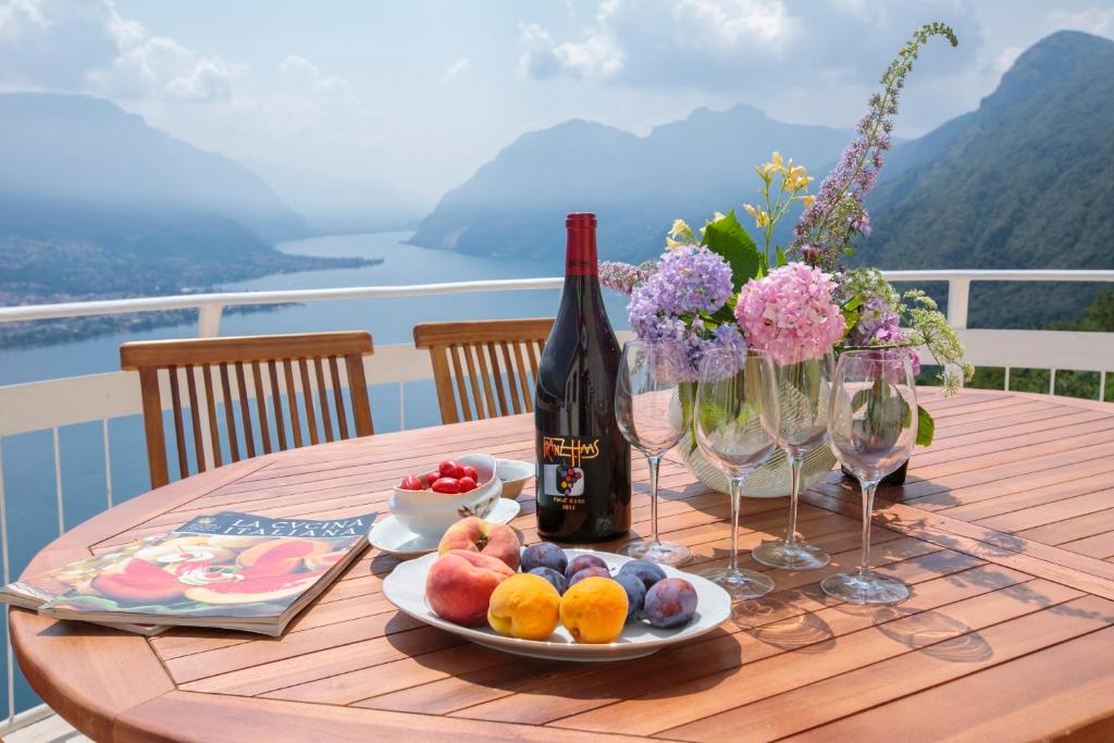 贝拉吉奥Villa Ponti Bellavista的一张桌子,上面放着一瓶葡萄酒和一盘水果