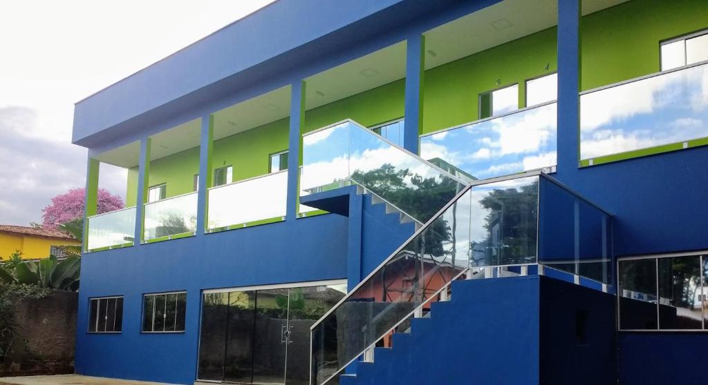 戈亚斯州上帕莱索Pousada das Cachoeiras的蓝色和绿色的建筑,设有楼梯
