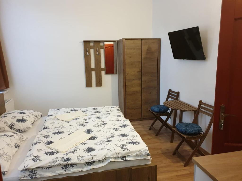 布达佩斯Guest House Orczy Park的配有一张床和一张桌子及椅子的房间