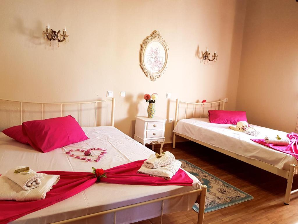 卡尔利拉基Dimitra's Garden Villa的客房内的两张床和粉红色的毛巾