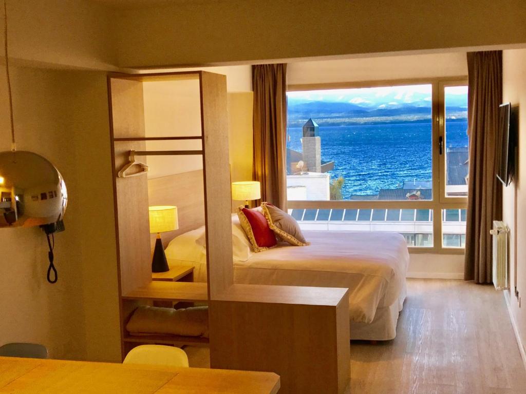圣卡洛斯-德巴里洛切MINI LOFT Departamentos Bariloche的酒店客房设有一张床和一个大窗户