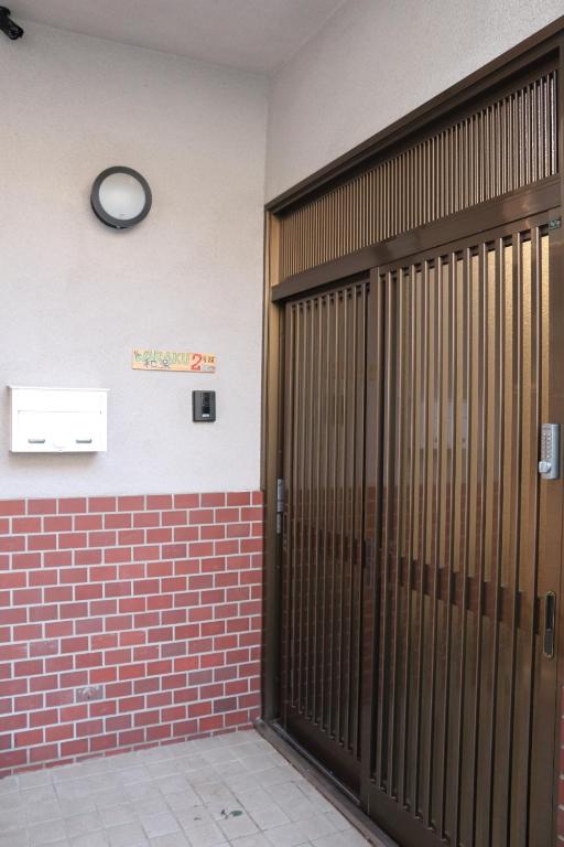 泉佐野KIX House 和楽二号館的一间设有两扇门和墙上一个时钟的房间