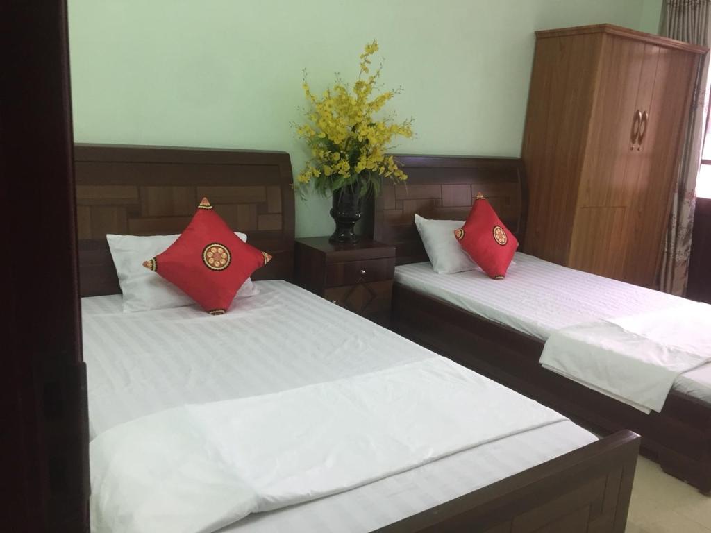 下龙湾Hân hân的客房内的两张床和红色枕头