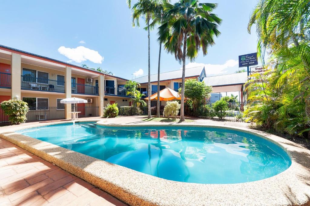 凯恩斯热带昆士兰酒店的棕榈树酒店前的游泳池