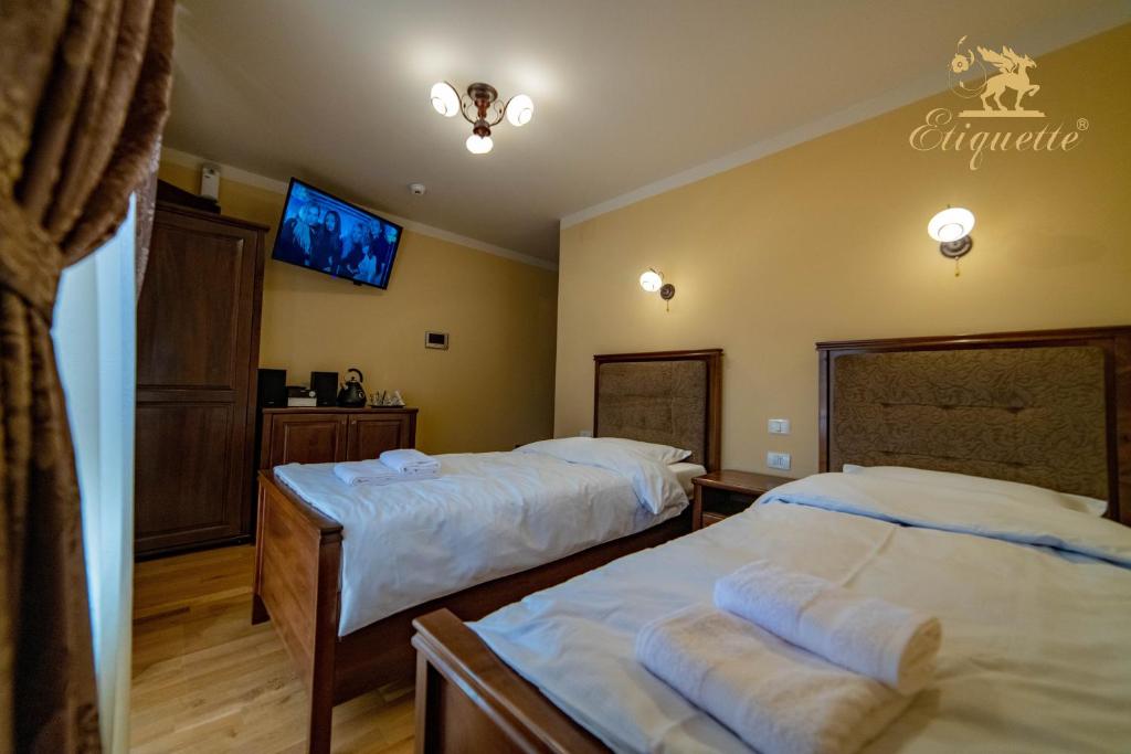 德瓦Villa Etiquette的一间卧室配有两张床和一台平面电视