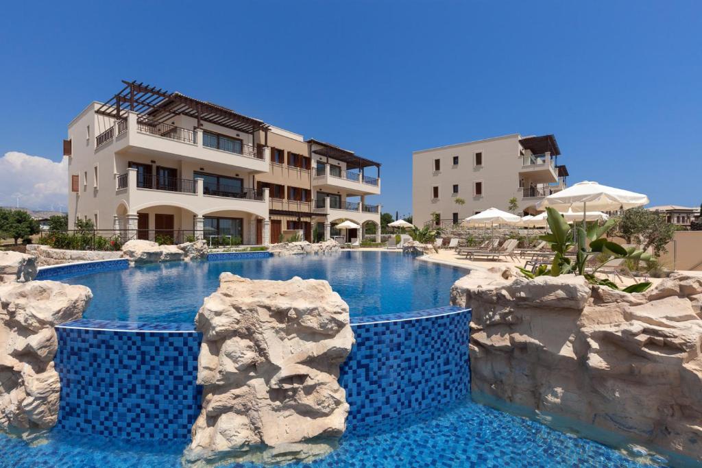库克里亚Aphrodite Hills Rentals - Premium Serviced Apartments的大楼前的蓝色海水游泳池