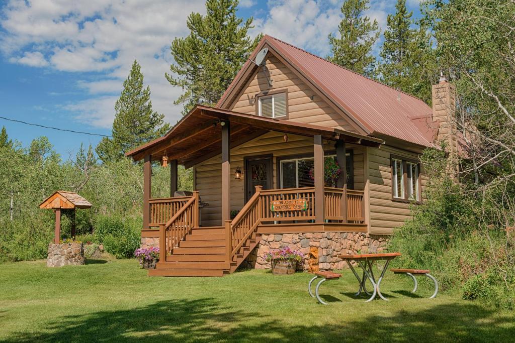 艾兰帕克Grandma's Cabin Yellowstone Vacation Home的小木屋设有门廊和甲板