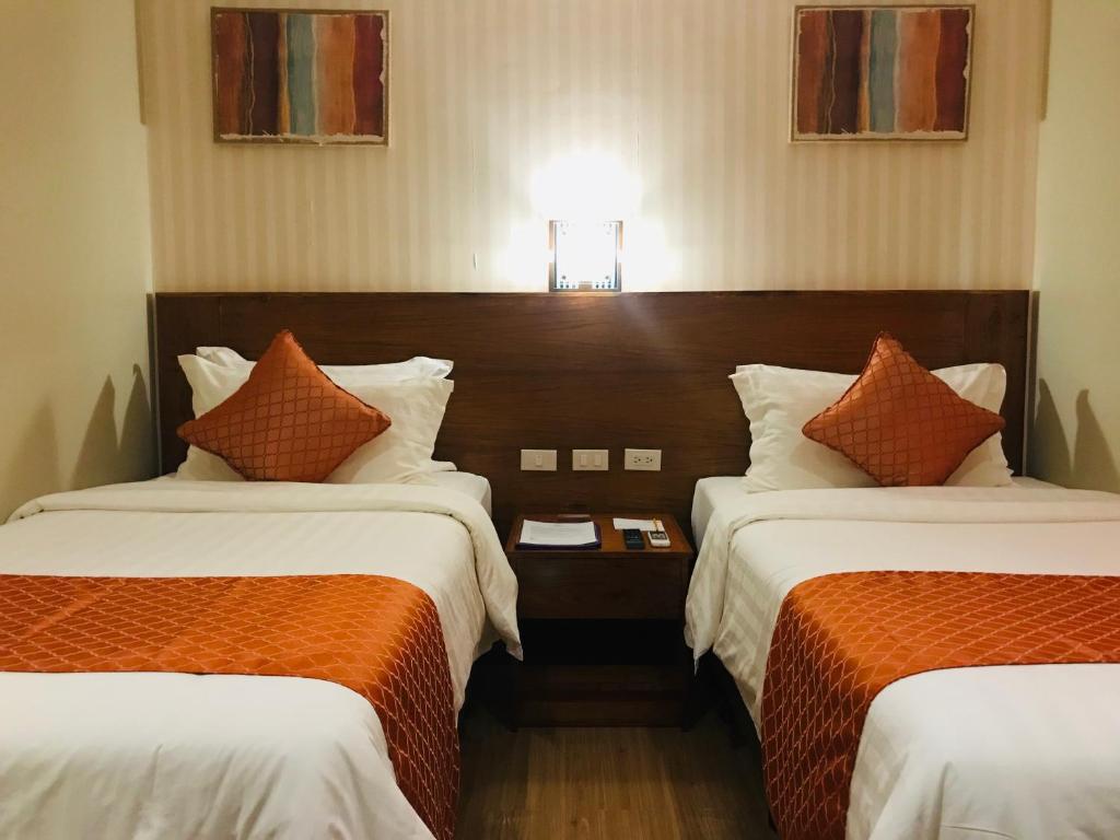 科隆科伦索雷快捷酒店的酒店客房带两张床,带橙色和白色的床单。