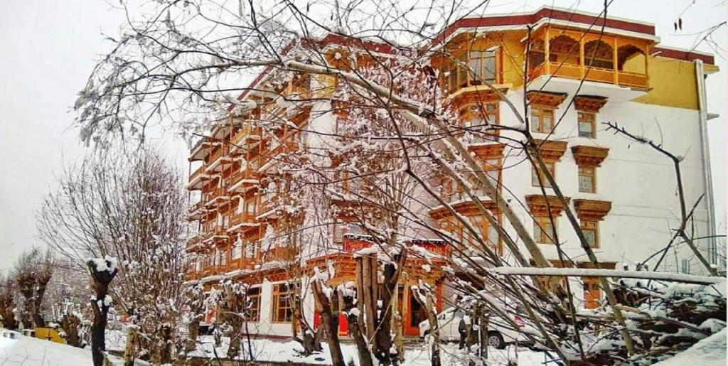 列城Hotel Grand Himalaya的树枝上积雪的大建筑