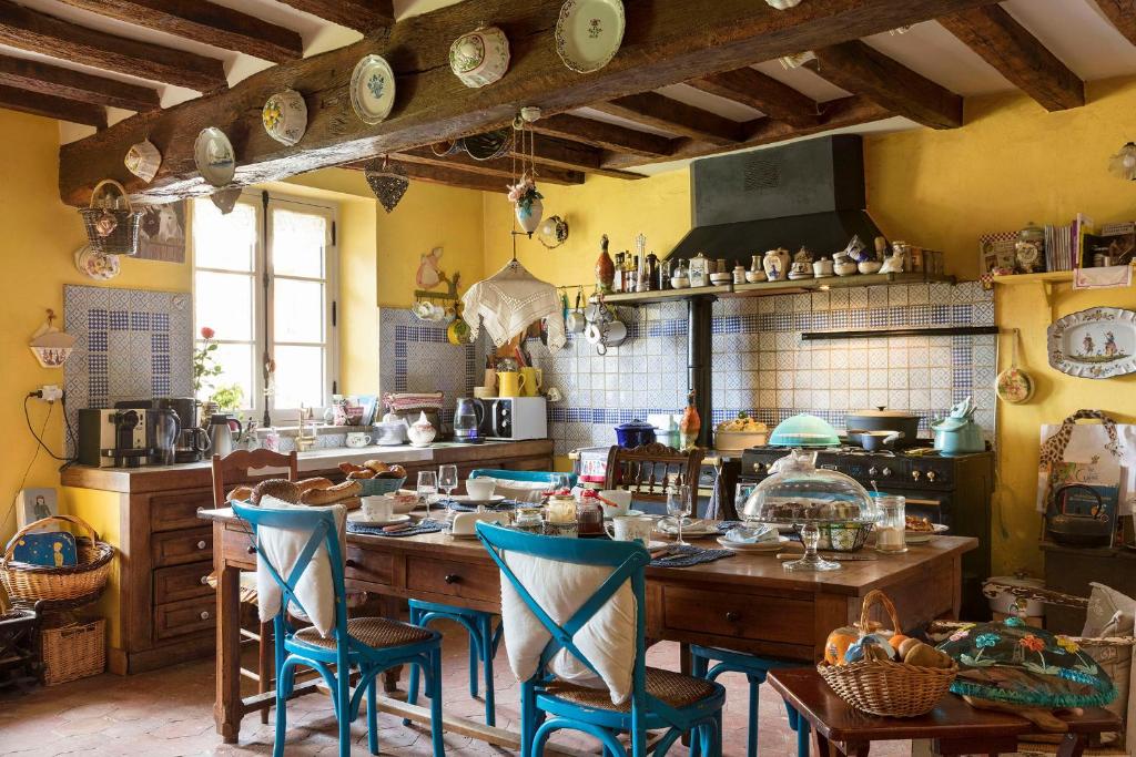 Mittainville蓝色阴影庄园住宿加早餐酒店的厨房配有木桌和蓝色椅子