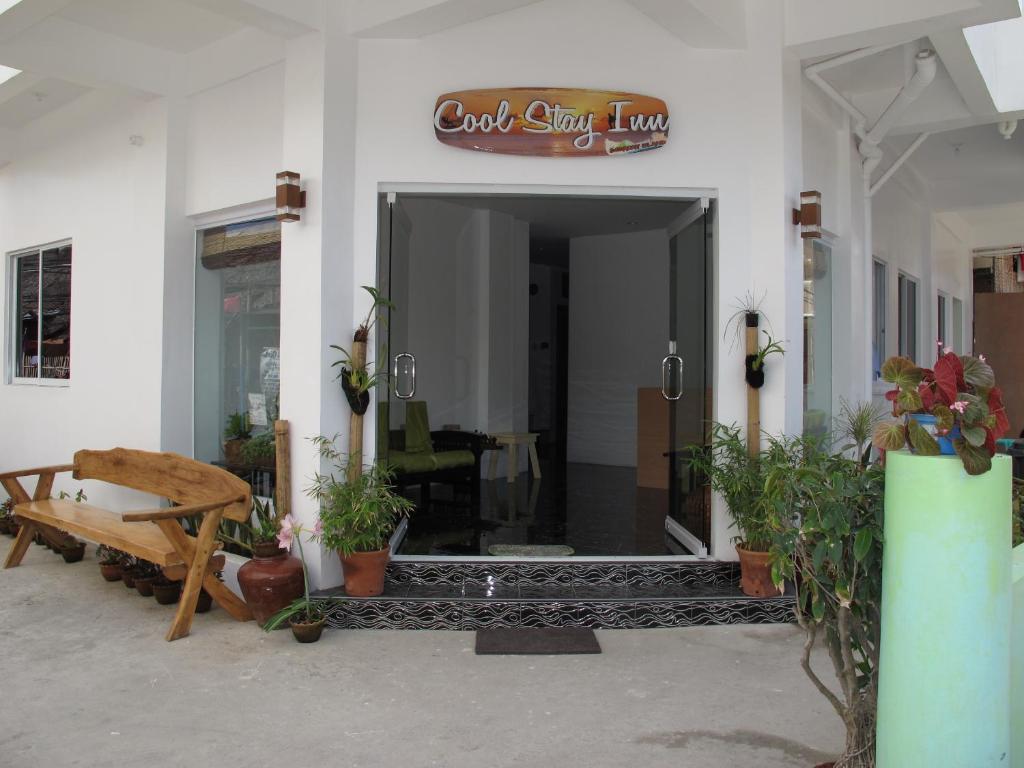 长滩岛Cool Stay Inn的长凳和植物的建筑物入口