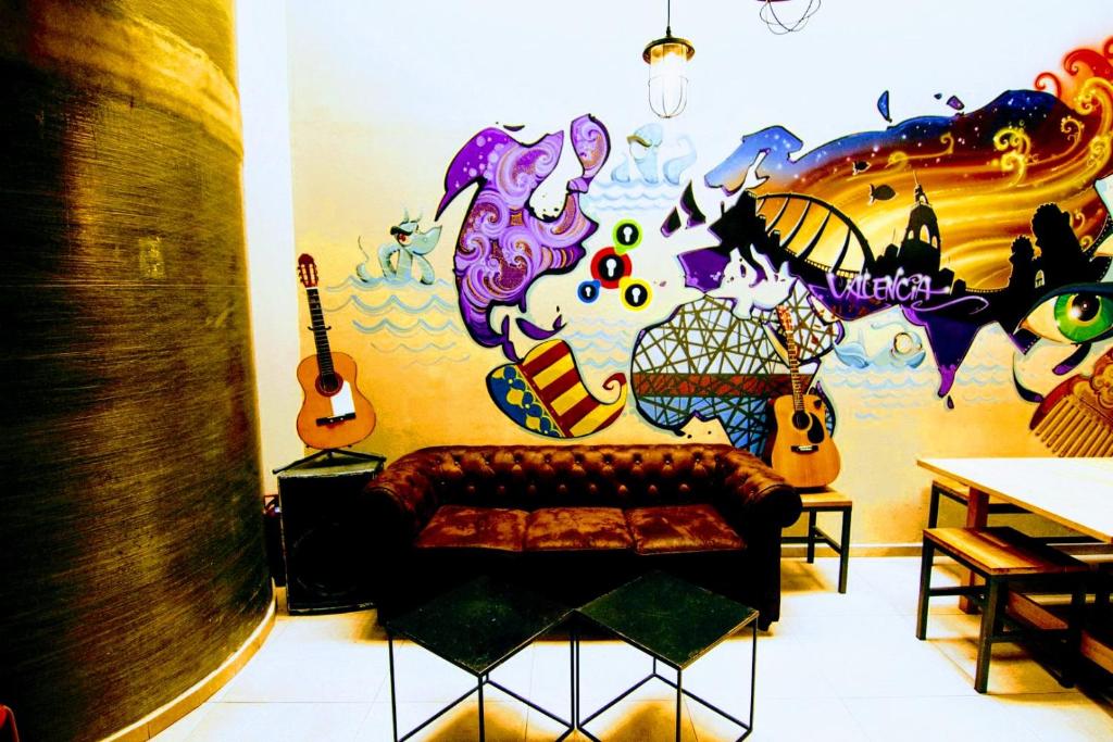 瓦伦西亚紫巢旅馆的带沙发和吉他墙的客厅