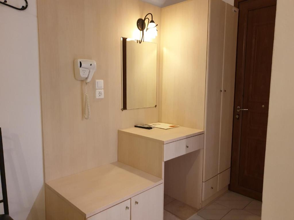 普拉提伊亚洛斯西弗诺斯Sifnos Hotel Benaki的一间带水槽和镜子的浴室以及一部电话