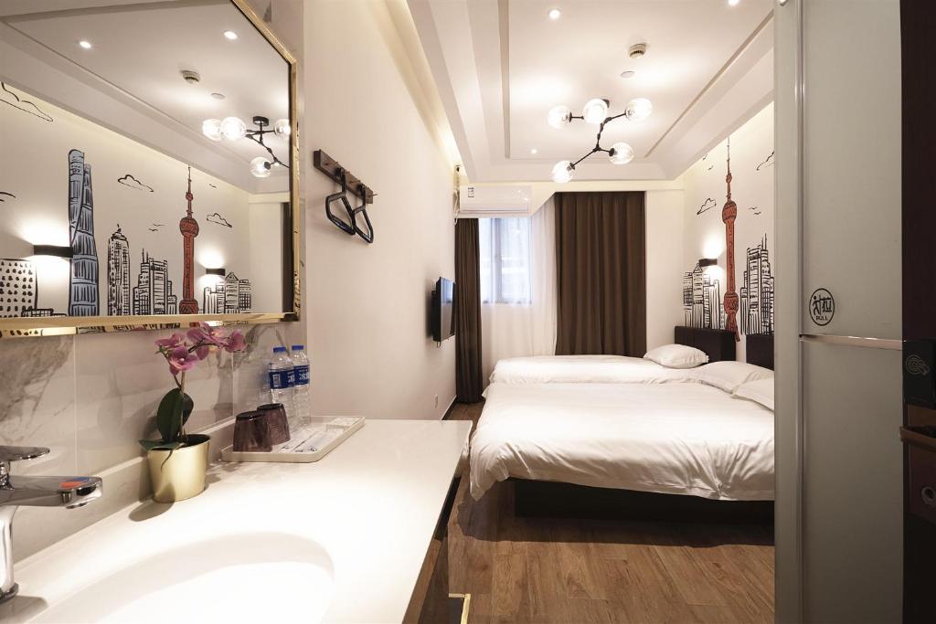 上海上海meego米果悦思酒店的浴室设有两张床、一个水槽和镜子