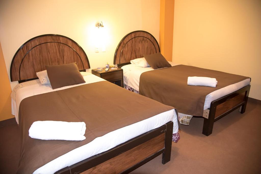 普诺HOSTAL MILAGROS INN - samary inn的一间酒店客房,房间内设有两张床