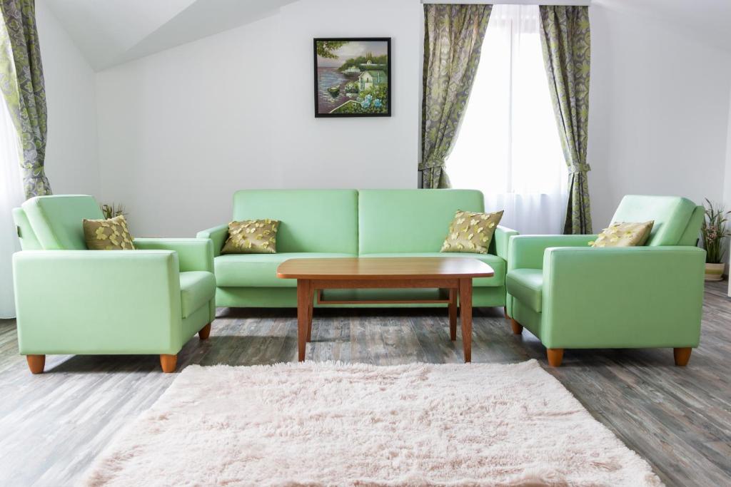 普罗夫迪夫Apartments Nasini的客厅配有两张绿色沙发和一张桌子