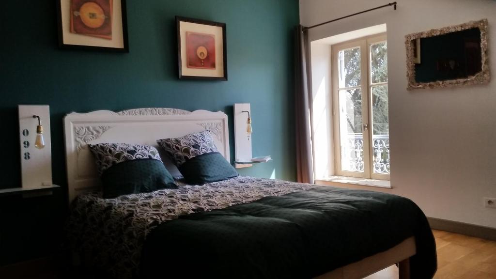 隆河省clos st Joseph的一间卧室配有一张蓝色墙壁的床和一扇窗户