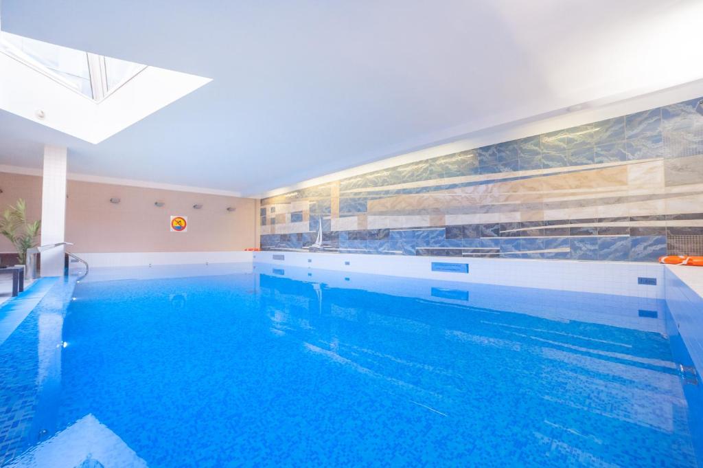 克拉科夫Premier Kraków Hotel的客房内的大型游泳池,有蓝色的水