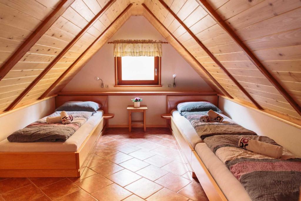 博希尼Holiday house Pokrovec - Bohinj的阁楼间 - 带两张床和窗户