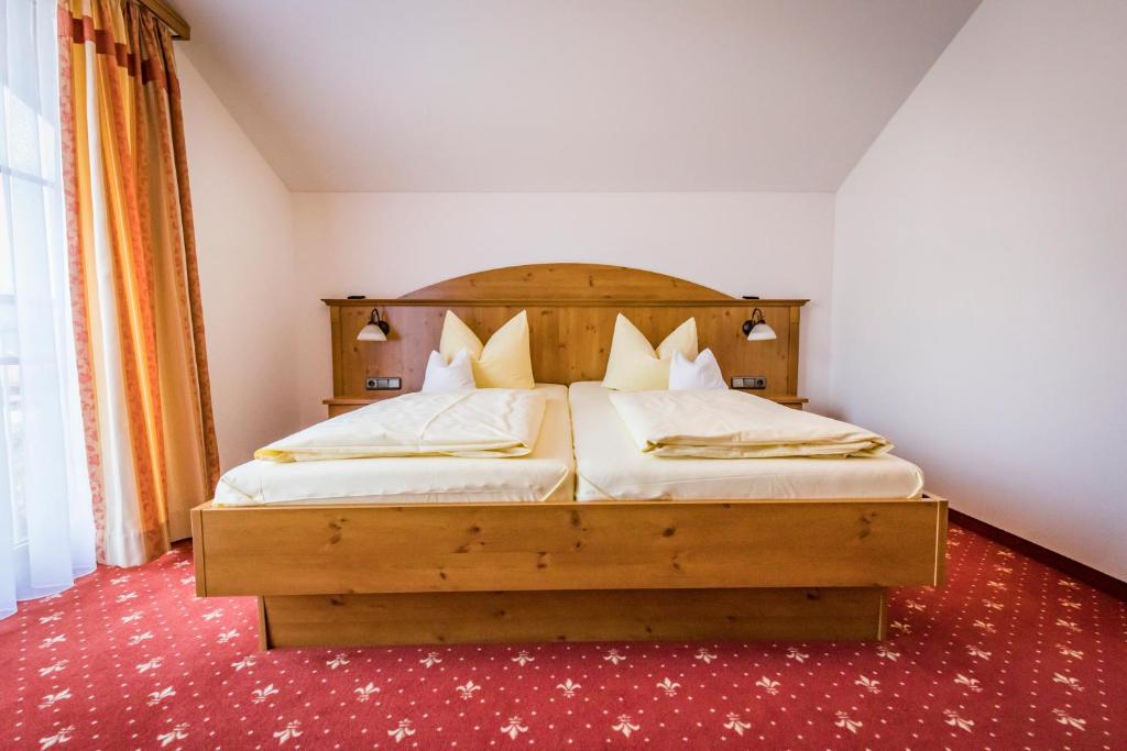 巴特莱辛哈尔Kurhotel Falter的一间卧室配有一张带木制床头板的床