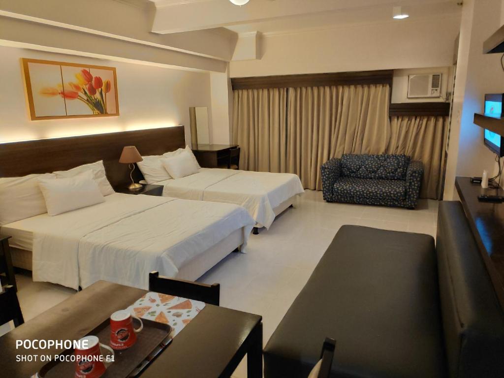 大雅台Tagaytay Staycation by Naya and Darla w Free Swimming Pool, WiFi & Netflix的酒店客房,配有两张床和椅子